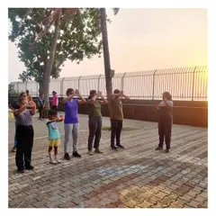 Every session starts with proper warm-ups. Here, our summer camp students are doing focus and stretching exercises against a beautiful sunset backdrop at our Dadar archery range.