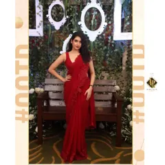 This is a custom-designed red georgette saree-gown for actress Malaika Vasupal. The outfit features delicate floral appliqué on the shoulder and hip, with a pre-draped silhouette that gives the elegance of a saree with the ease of a gown.