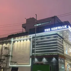 An evening shot of 'The Sidewalk' commercial building, showcasing the full extent of the facade lighting I designed. The illuminated frame on the left is designed for large-format advertising, adding to its commercial viability.