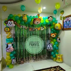 A fun Jungle theme birthday decoration featuring a green balloon arch decorated with various animal foil balloons. This setup is perfect for creating a wild adventure right in your living room.
