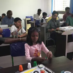 Here you can see the fun in action. Students, both young and old, are getting hands-on with their personal magic kits, practicing the cups and balls trick. This is what my workshops are all about: interactive learning for everyone.