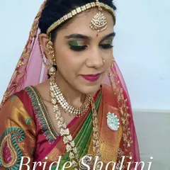 Here is a close-up of the bride's Varapooja makeup, with a sheer veil. The focus is on the bold green and gold eyeshadow and a deep berry lip, a classic combination for South Indian pre-wedding ceremonies.