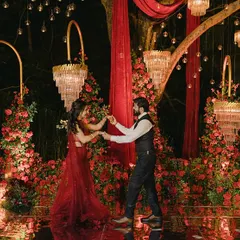 A passionate first dance surrounded by a sea of red roses and dramatic chandeliers. The mirrored dance floor reflects the entire scene, doubling the glamour and creating a breathtaking visual.