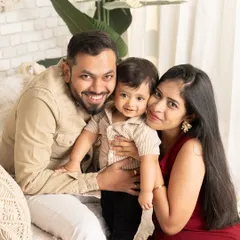 A cozy and happy family portrait. This close-up shot captures the tight-knit bond of this family of three in a relaxed studio setting.