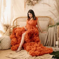 A full-length view of a stunning orange ruffled gown within our boho set. This shot showcases how we combine high-fashion gowns with our themed decor for a unique look.
