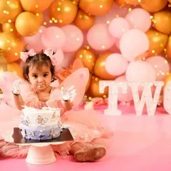 Two looks so sweet! This little fairy is having the best time at her second birthday cake smash, with frosting on her face and a big smile. It's never too late for a fun smash session.
