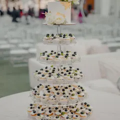 A full view of the wedding cupcake tower. The five tiers of mini cupcakes create a sense of grandeur, leading up to the main cake. It's a fantastic alternative to a traditional multi-tiered wedding cake.