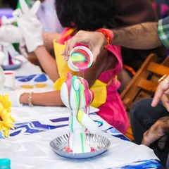 A guest gets creative with 3D fluid painting on a bear figurine, one of our most popular hands-on art activities.