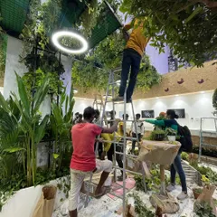 Teamwork makes the dream work. Here, our crew is installing a complex ceiling of hanging greenery, a service that dramatically transforms the atmosphere of any large room or hall.