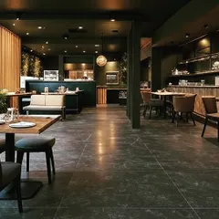 This restaurant interior uses a dark color palette, wood accents, and warm spotlights to create a cozy and intimate atmosphere. The layout includes a mix of booth seating and freestanding tables for flexibility.