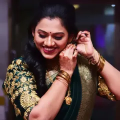 The final touches make all the difference. This shot captures the joy and elegance of the bride-to-be as she puts on her earrings, her makeup and hair perfectly styled for her Marathi engagement ceremony.