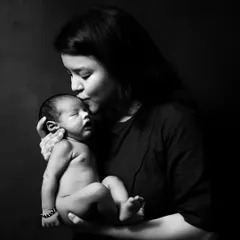 This dramatic black and white image of a mother holding her newborn is pure art. I use lighting to create emotional, powerful portraits that highlight the mother-child bond.