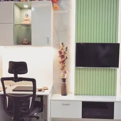 This custom unit combines a work-from-home study desk with a TV wall unit. The design uses a mix of white and pastel green panels, with overhead cabinets for extra storage.
