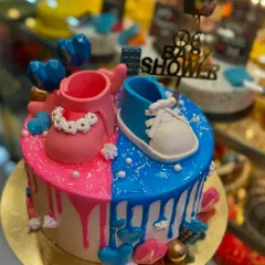 This adorable baby shower cake is perfect for a gender reveal party. It's split into pink and blue themes, decorated with tiny fondant baby shoes and a 'Baby Shower' topper.