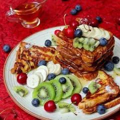 Another angle of the beautifully arranged French toast breakfast, complete with a side of syrup. This series shows how different perspectives can be used in a single food photoshoot.