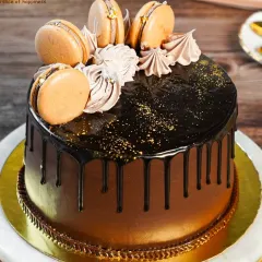 Indulge in pure elegance with our Chocolate Macaron Cake. A rich chocolate drip cake is crowned with delicate, handcrafted macarons for a truly luxurious dessert experience.