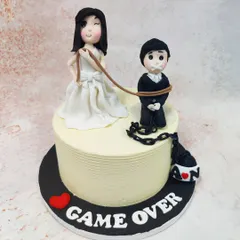 This cheeky "Game Over" wedding cake adds a touch of humor to the big day, featuring a bride playfully holding a leash attached to her groom.