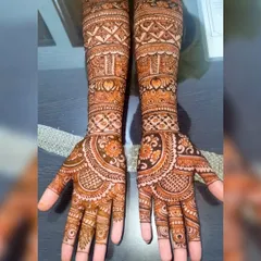 A beautiful example of full coverage bridal henna. This design features symmetrical patterns on both arms, with bands of geometric work and traditional Indian motifs for a classic look.