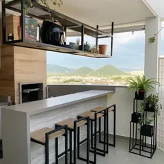 Even a modern, minimalist space can be enhanced with plants. For this balcony bar, we added a few carefully chosen plants in simple pots and a multi-tiered stand to soften the look without cluttering the stunning view.