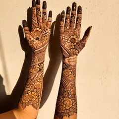 The sunlight brings out the warm, rich tones of this mature bridal henna stain. The color is consistent from the fingertips all the way up the arms.