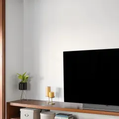A detail shot of the family space in our 'Gulmohar' project, showing the clean lines of the TV unit and the warm wooden ledge that runs across the wall.