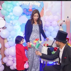 The birthday girl helps the magician with a classic flower bouquet trick, making her part of the show.