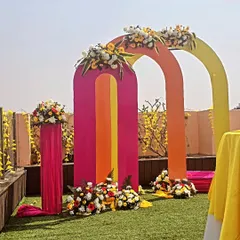 Planning a fun, modern haldi ceremony? We love playing with color, like these vibrant pink, orange, and yellow arches for a daytime garden event. This setup makes for incredible photos and a joyful atmosphere.
