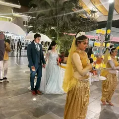 My professional dance crew adds that touch of royal treatment. Here, they are dressed in full gold glam, lighting the way for the couple with candelabras and umbrellas for a truly grand welcome.