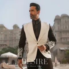 A modern twist on the classic tuxedo. This sleeveless white blazer is designed with sharp lapels and detailed embroidery on the sleeves of the underlying shirt, creating a layered, powerful look.