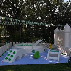 A dedicated soft play area for the youngest guests at the Tennis Club party. This safe and fun zone included a ball pit, a small slide, and ride-on toys, all in a clean white and green colour scheme.