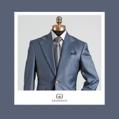 A detailed view of the light blue suit, highlighting the texture and the elegant pairing with a grey patterned tie and pocket square.