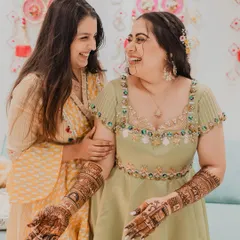 The bride sharing a laugh with her friend during her Mehendi ceremony. We focus on capturing the bonds of friendship and the happy, relaxed atmosphere.