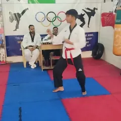 A student performs his Poomsae in front of the judging panel during the black belt test.
