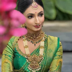 A perfect example of a classic South Indian Muhurtham look. This bride's radiant makeup features a flawless base that glows, defined eyes, and traditional jewelry, all complementing her vibrant green Kanjeevaram saree. This is a timeless look I specialize in.