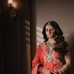 A serene bridal portrait, using natural window light to create a soft, painterly effect. A moment of quiet before the ceremony begins.