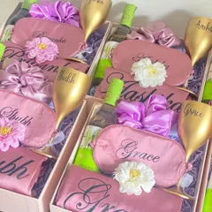 Time to celebrate with your girls! This bridesmaid hamper includes a personalized unbreakable wine glass, a mini bottle of white wine, a custom robe and eye mask, and a matching scrunchie. It's a party in a box!