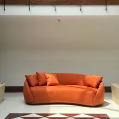 We love a bold color moment. This custom-curved sofa in a vibrant orange isn't just a piece of furniture; it's a statement. We work with you to pick fabrics and shapes that match your personality.