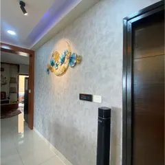 In this hallway, a multi-function Xeon touch panel is installed next to a smart tower fan and decorative wall art. This setup shows how we integrate control for lighting, climate, and other appliances into one convenient location.