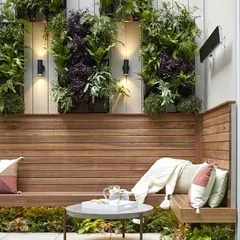 Here, I built a custom wooden bench and integrated it with vertical plant frames. The combination of warm wood, soft cushions, and living green walls makes this a uniquely beautiful and comfortable outdoor seating area.