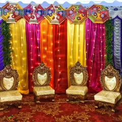 We bring the fun to pre-wedding events with vibrant stage decor. This mehndi setup uses a rainbow of colorful drapes, traditional umbrellas, and warm fairy lights to create a joyful and festive atmosphere for the celebration.