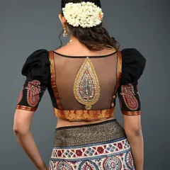 I love combining traditional elements with modern silhouettes. This black blouse features a sheer net back with an intricate, embroidered paisley motif, creating a look that is both elegant and alluring. The puffed sleeves add a touch of drama, making it a perfect choice for weddings and festive events.