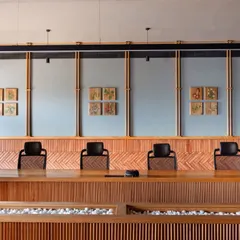 The boardroom at Anthea Pharma was designed with acoustics as a primary focus. We used a combination of brick cladding in a herringbone pattern and custom acoustic panels framed by teakwood spindles to create a space that is both sonically optimized and visually warm, perfect for high-level corporate discussions.