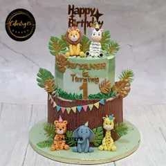 A vibrant two-tier jungle safari cake for a first birthday. This 5kg chocolate cake features a host of handcrafted fondant animals, including a lion, zebra, tiger, elephant, and giraffe.