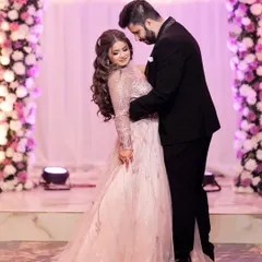 A classic romantic pose from an engagement shoot. The couple is framed by a beautiful floral arch, and the soft lighting creates a dreamy atmosphere.