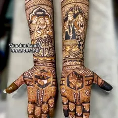 This unique bridal mehendi tells a complete family story. One arm shows the bride with her parents, while the other depicts the varmala ceremony, creating a beautiful narrative.