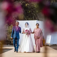 A walk to remember. The bride is escorted down the aisle by her parents, a significant and emotional moment at the start of the ceremony.