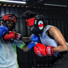A female fighter lands a solid right hand during a mixed sparring session. Training with different partners, regardless of gender, makes you a more adaptable boxer.