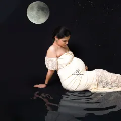 A celestial dream by the water. This composite image places the mom-to-be under a full moon with her reflection in the water, creating a serene, magical, and otherworldly maternity portrait.