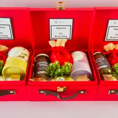 These red suitcase hampers were customized for "Mossimo Clothing," featuring their logo and a "Happy Diwali" message on a card inside.