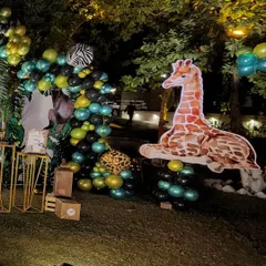 The other side of the safari party backdrop, featuring a large giraffe cutout resting on a cluster of green and black balloons. This creates a balanced and symmetrical look for the main photo area.